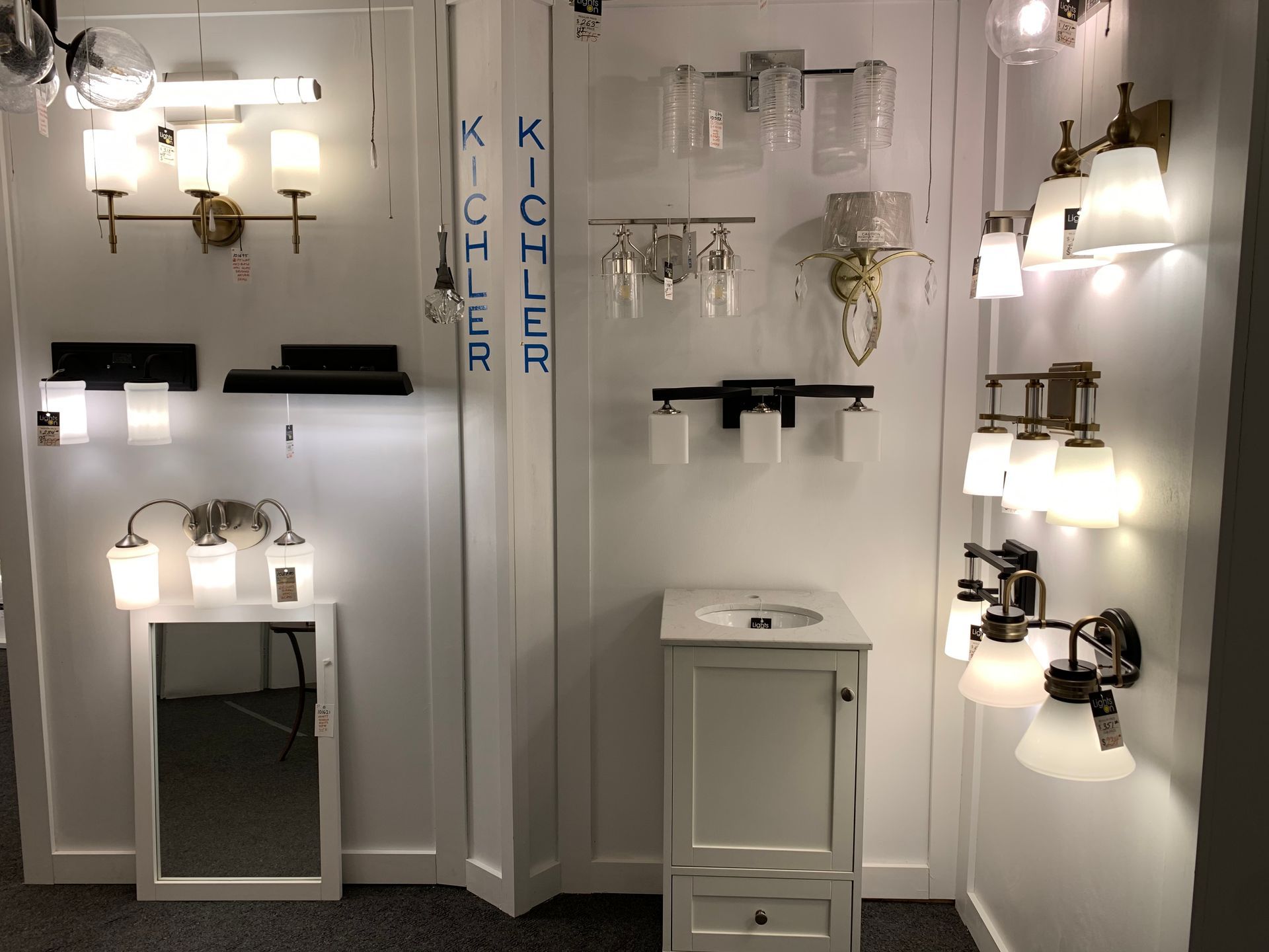 A bathroom with a sink , mirror , and lights on the wall.