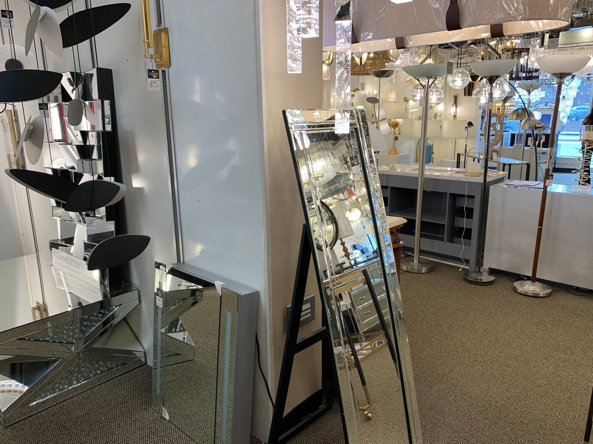 A full length mirror is sitting on a stand in a store.