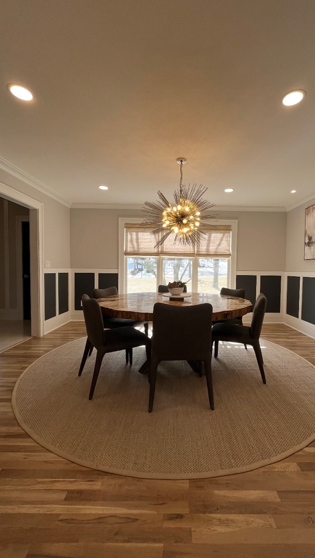 A dining room with a round table and chairs and a chandelier.