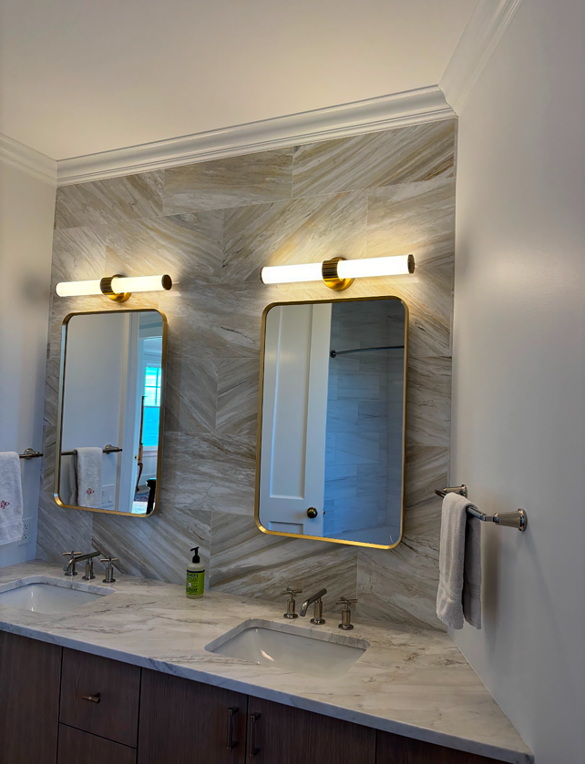 A bathroom with two mirrors and a sink.