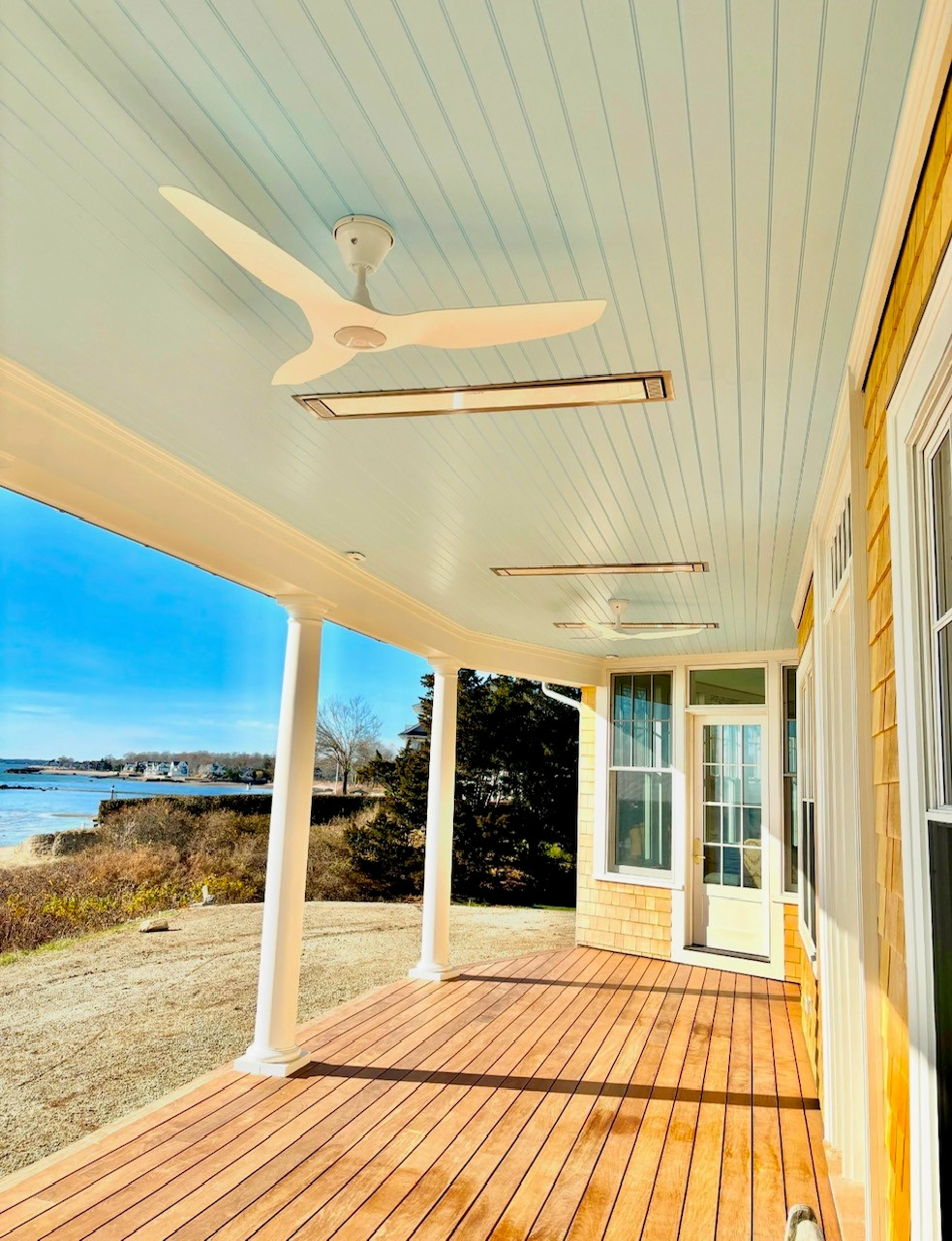 A porch with a ceiling fan and a view of the ocean.