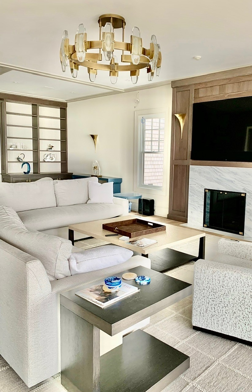 A living room with a couch, chair, coffee table, and fireplace.