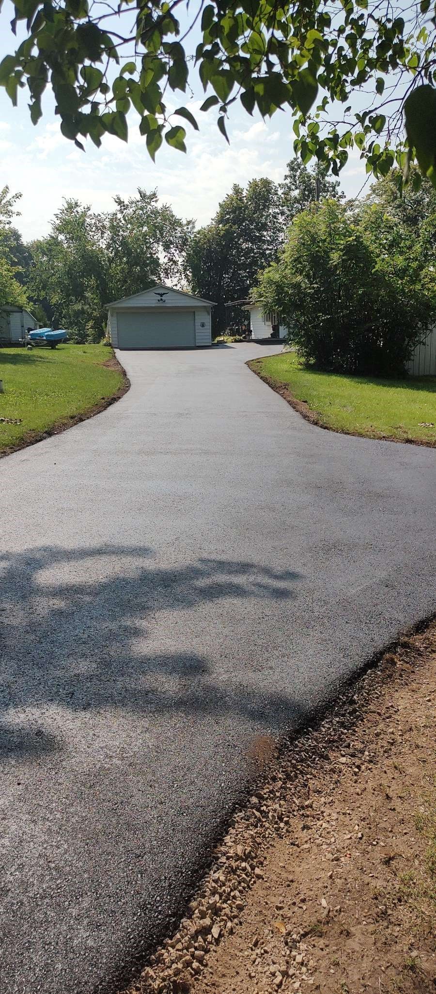 A newly paved driveway leading to a house.