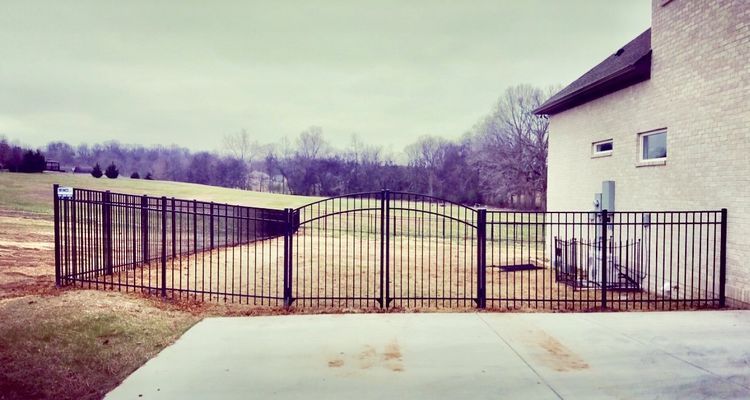 A white house with a black fence in front of it.