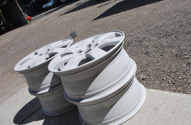 Two white wheels are sitting on a concrete surface