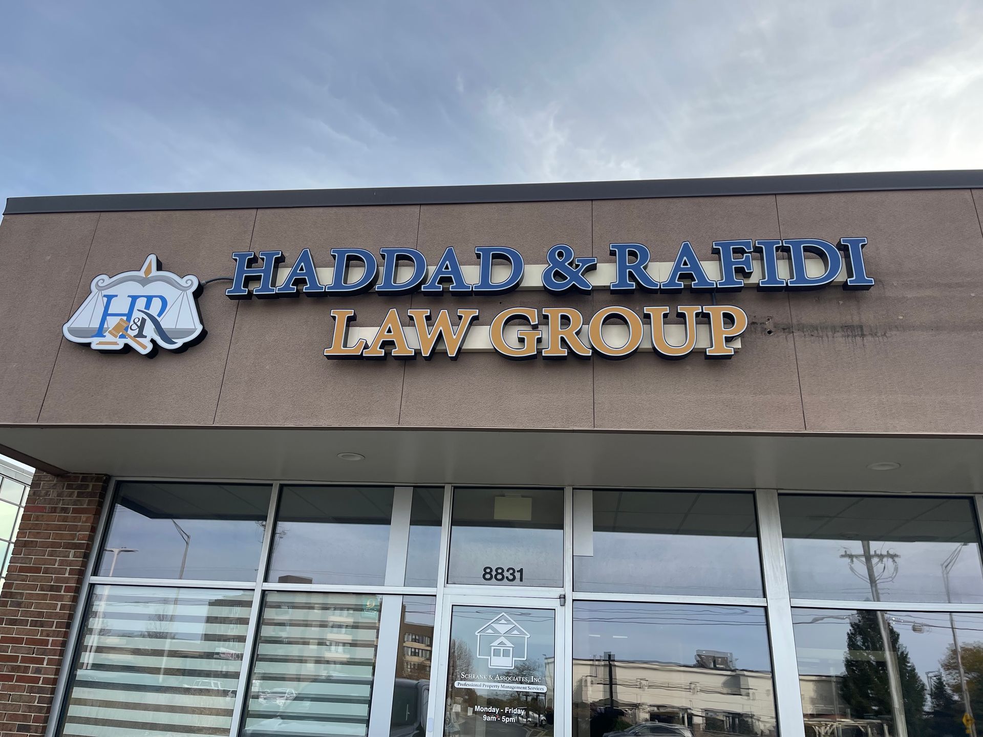 Sign for Haddad & Rafidi Law Group on a building with a blue sky background.