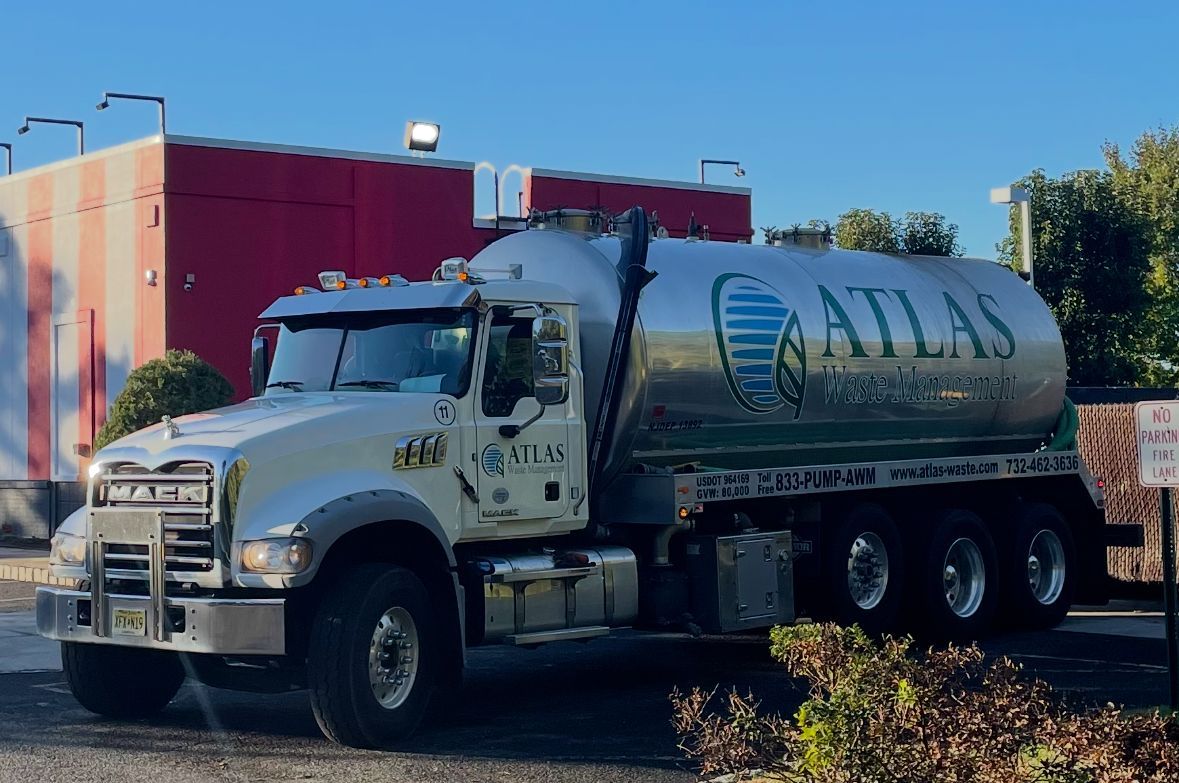Silver Atlas Environmental services truck parked in front of a building.