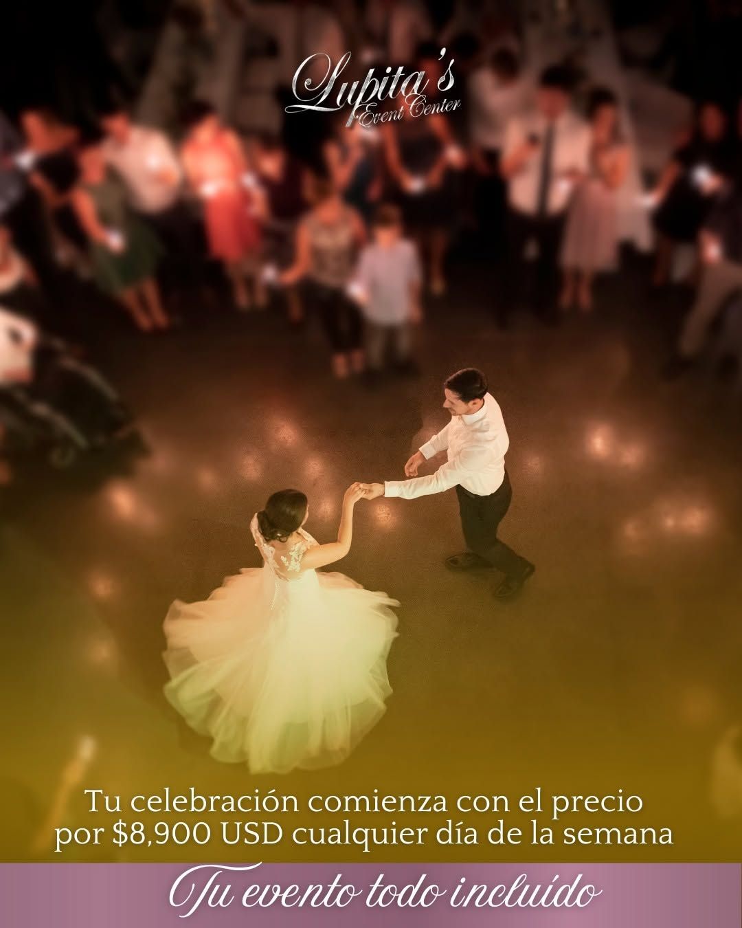 Couple dancing at a candlelit event, surrounded by guests in a warm, blurred reception setting.