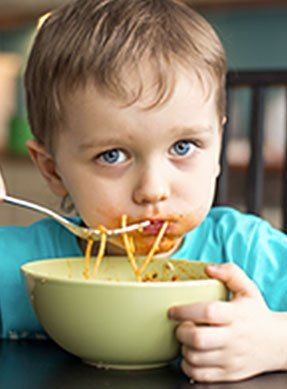 child eating noodles