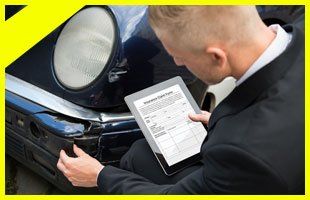 Insurance agent inspecting damaged car with insurance claim form on digital tablet
