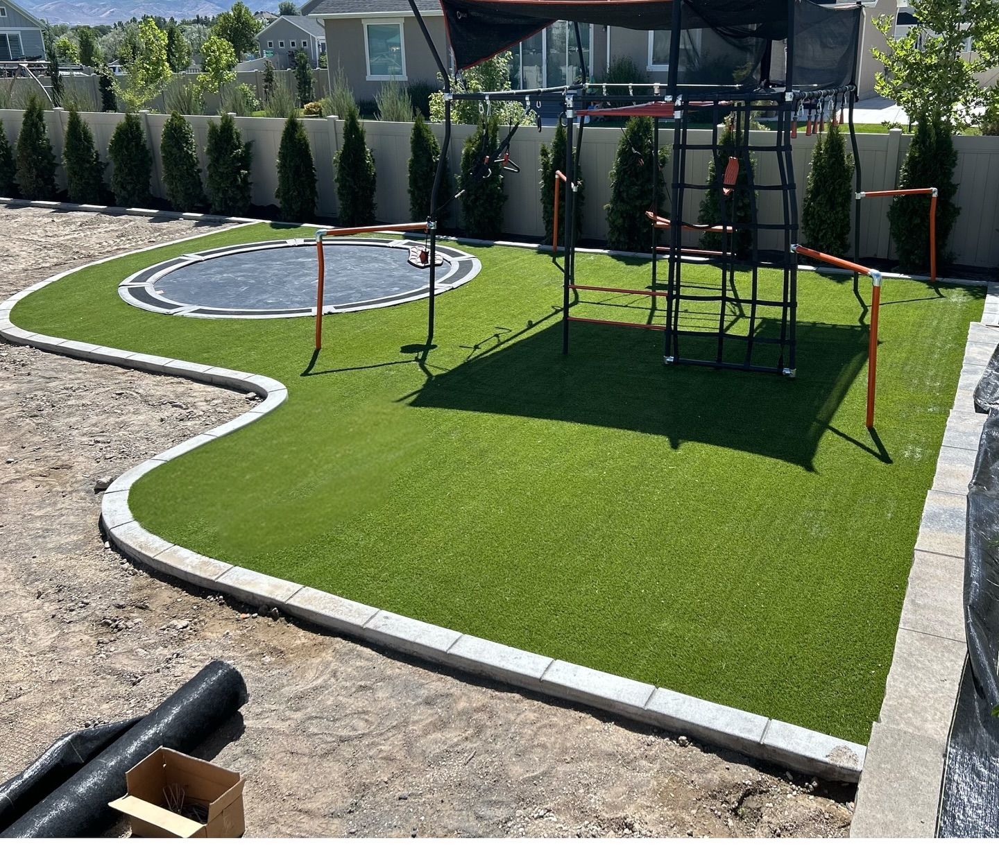 Backyard mini golf area with artificial turf, putting green, and obstacle posts by a house