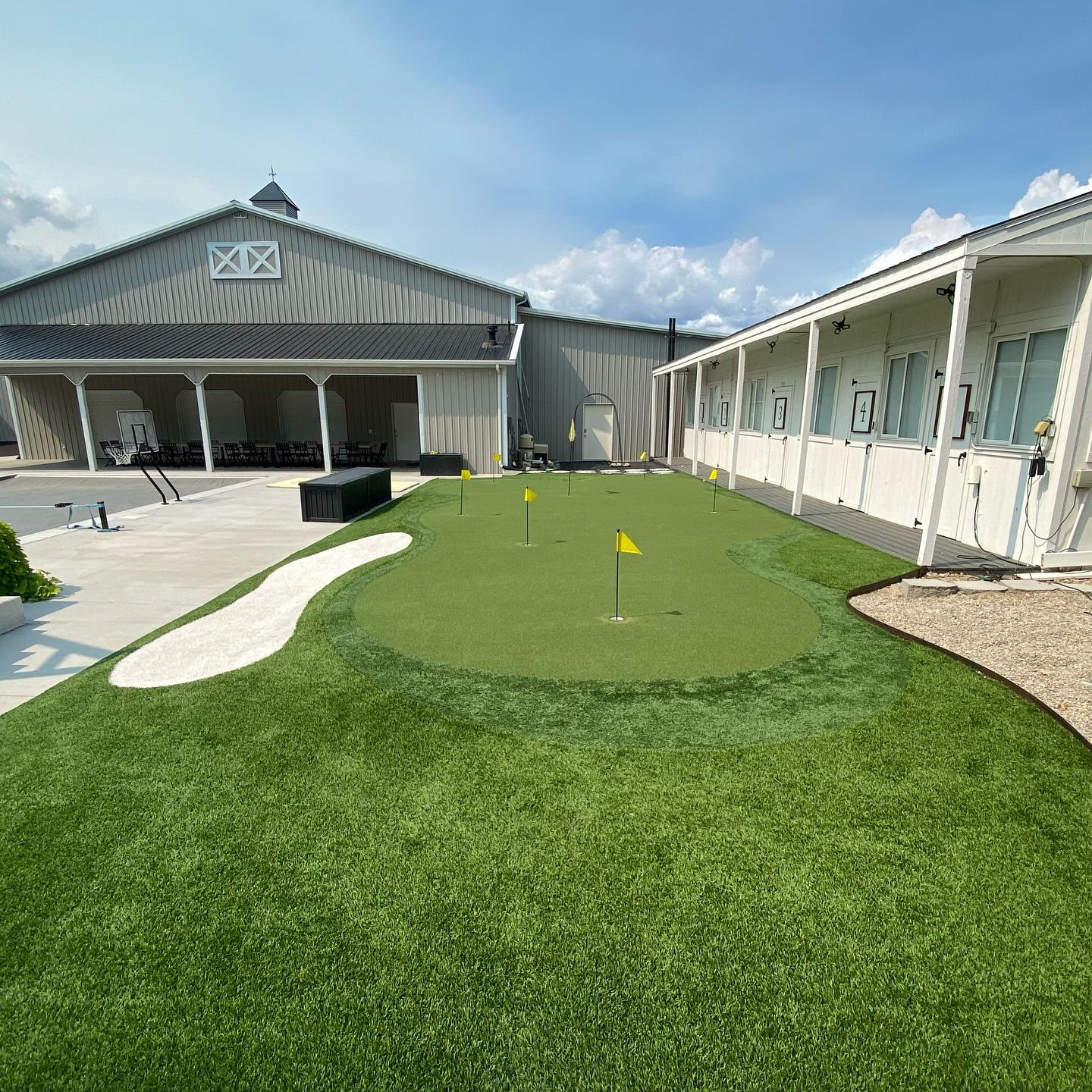 Courtyard putting green between two white buildings under a blue sky