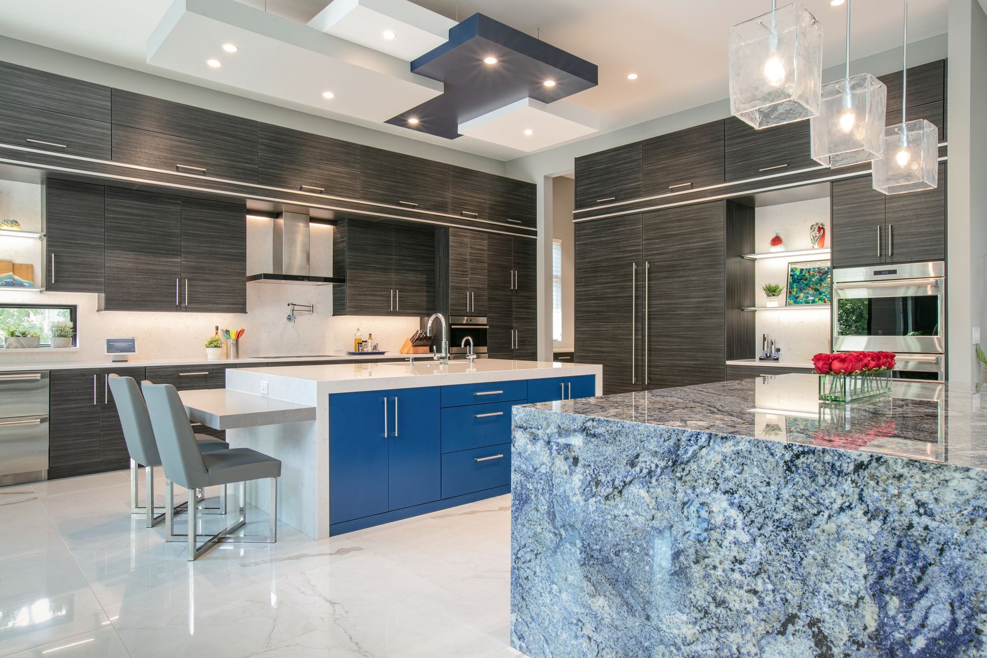 Modern kitchen with blue and white accents, dark gray cabinets, and a granite countertop.