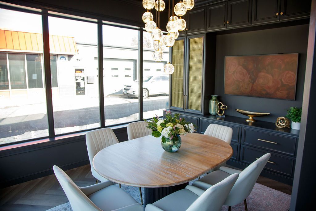 Modern dining room with oval table, six chairs, and large window.