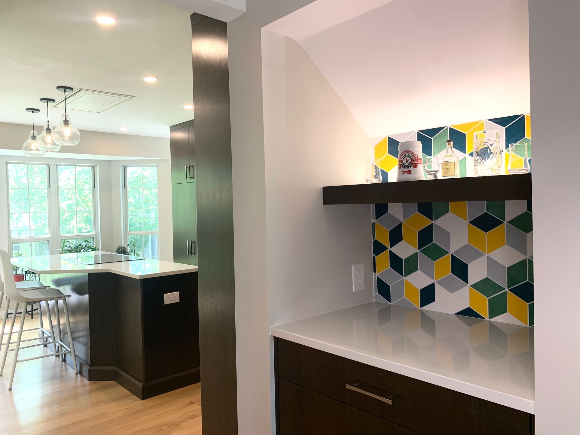 Interior view of kitchen and built-in alcove with counter, shelving, and colorful tile.