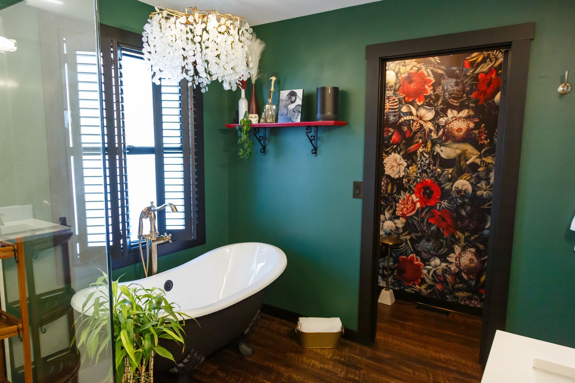 Green bathroom with a clawfoot tub, dark trim, and floral shower curtain.