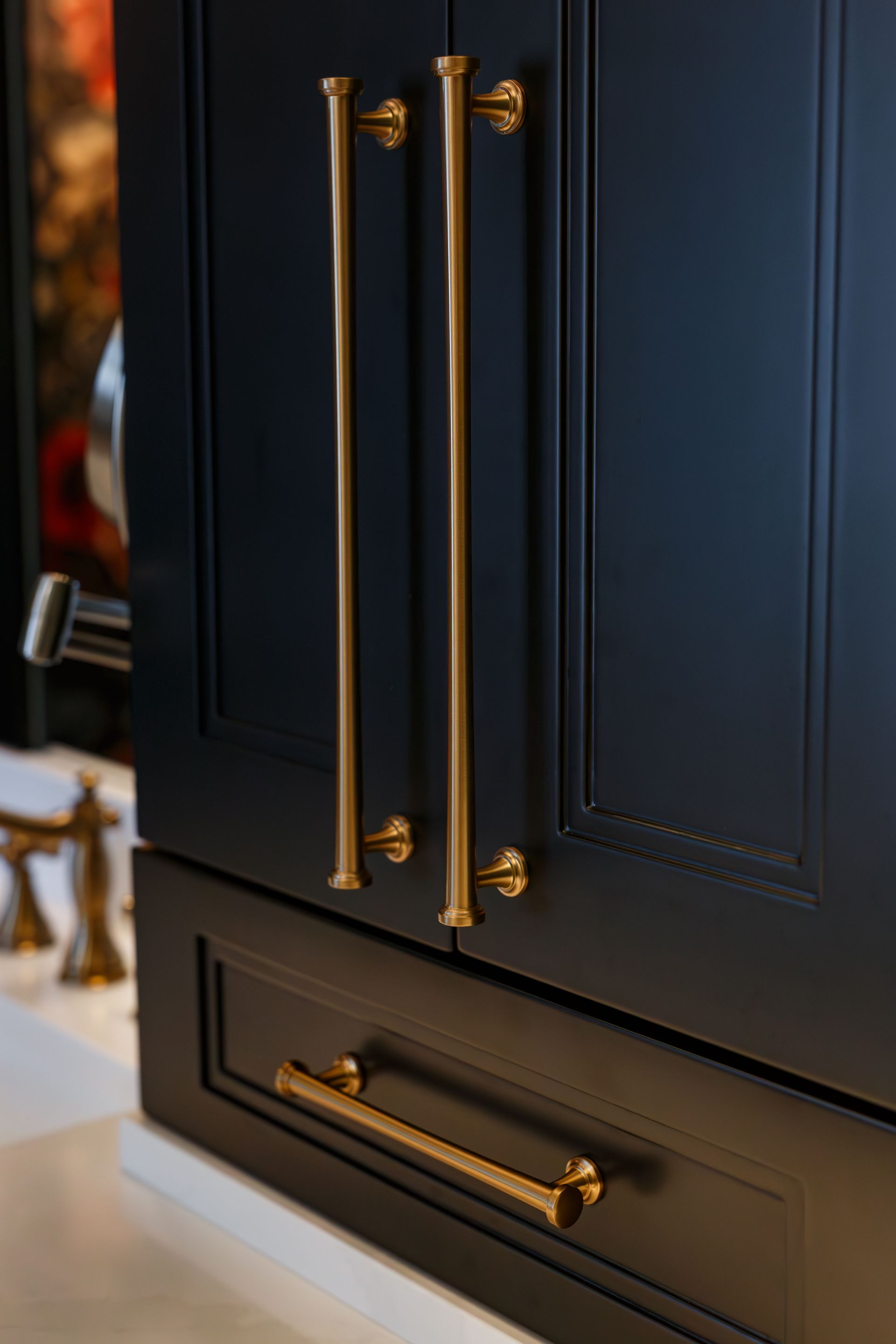 Dark blue kitchen cabinet with brass handles.