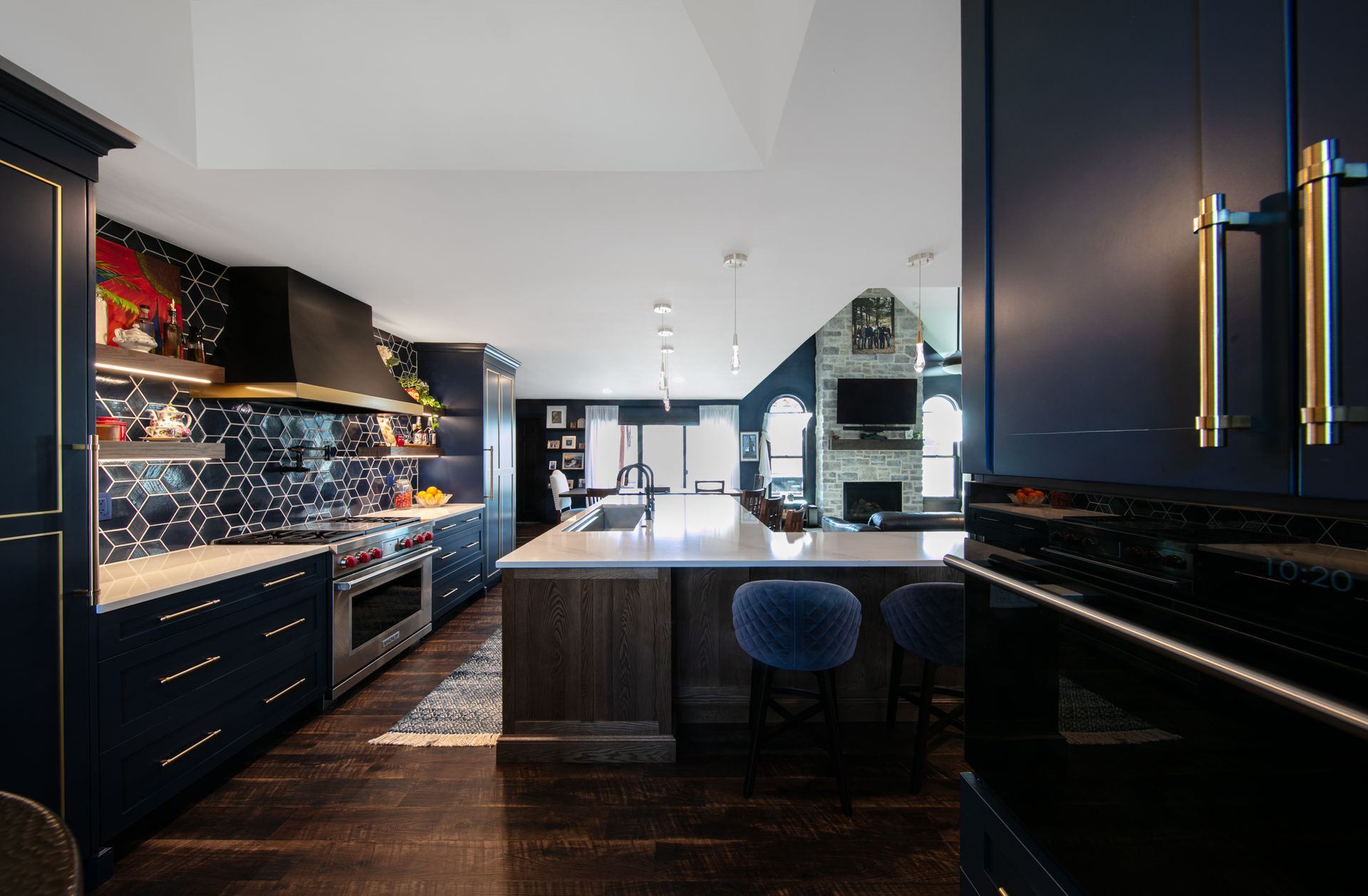 Navy blue kitchen with long island and stainless steel appliances.