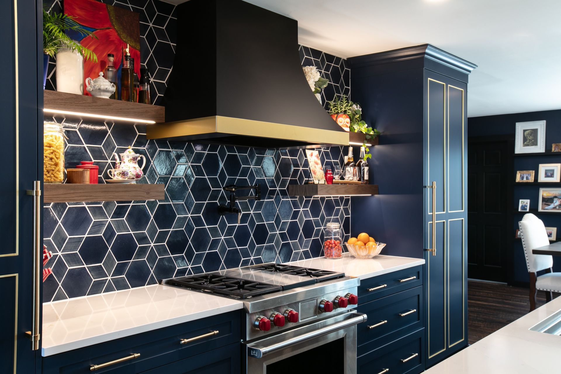 Navy blue kitchen with gold accents and geometric backsplash tile.