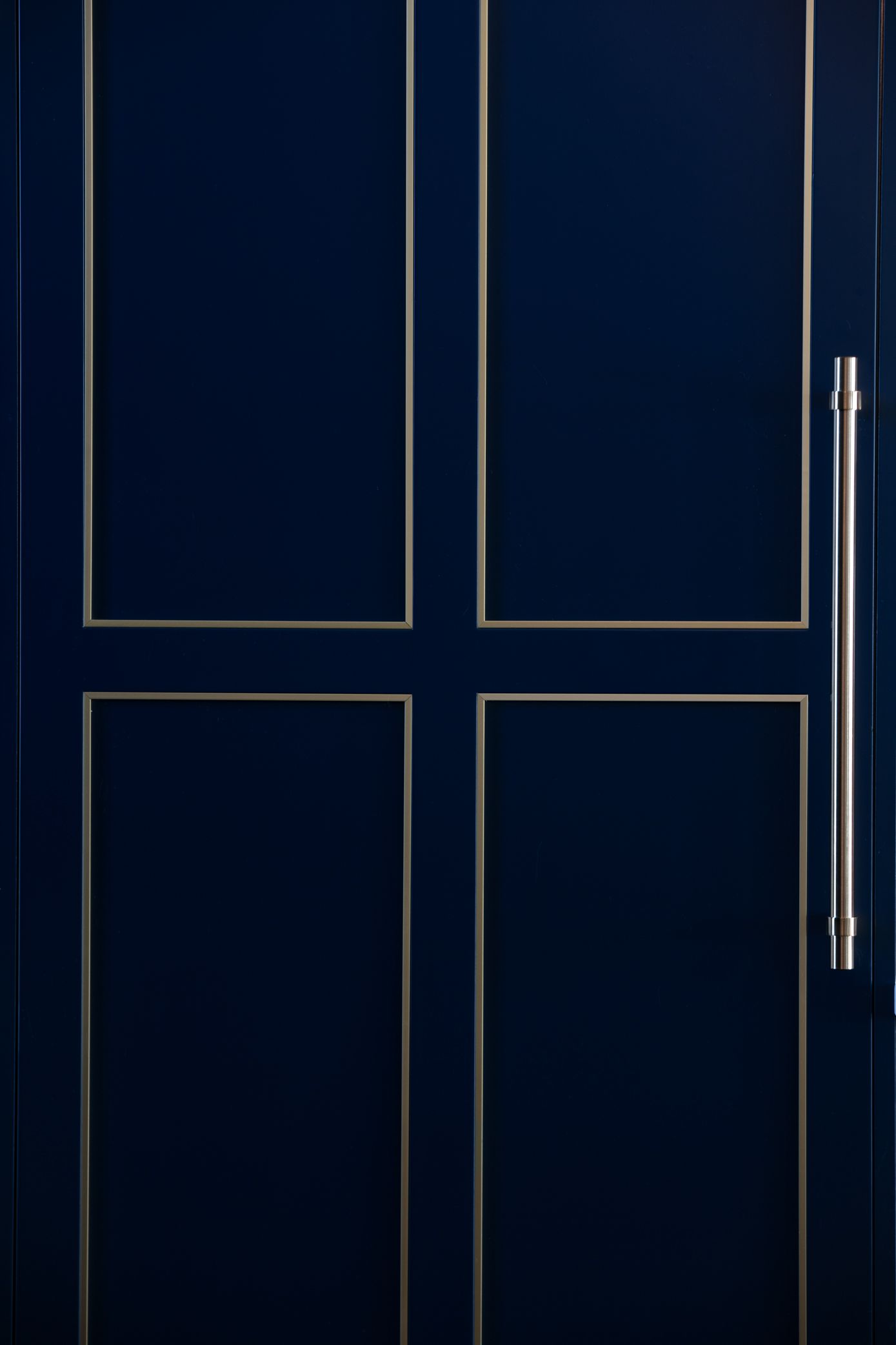Blue door with four panels, silver trim, and silver vertical handle.