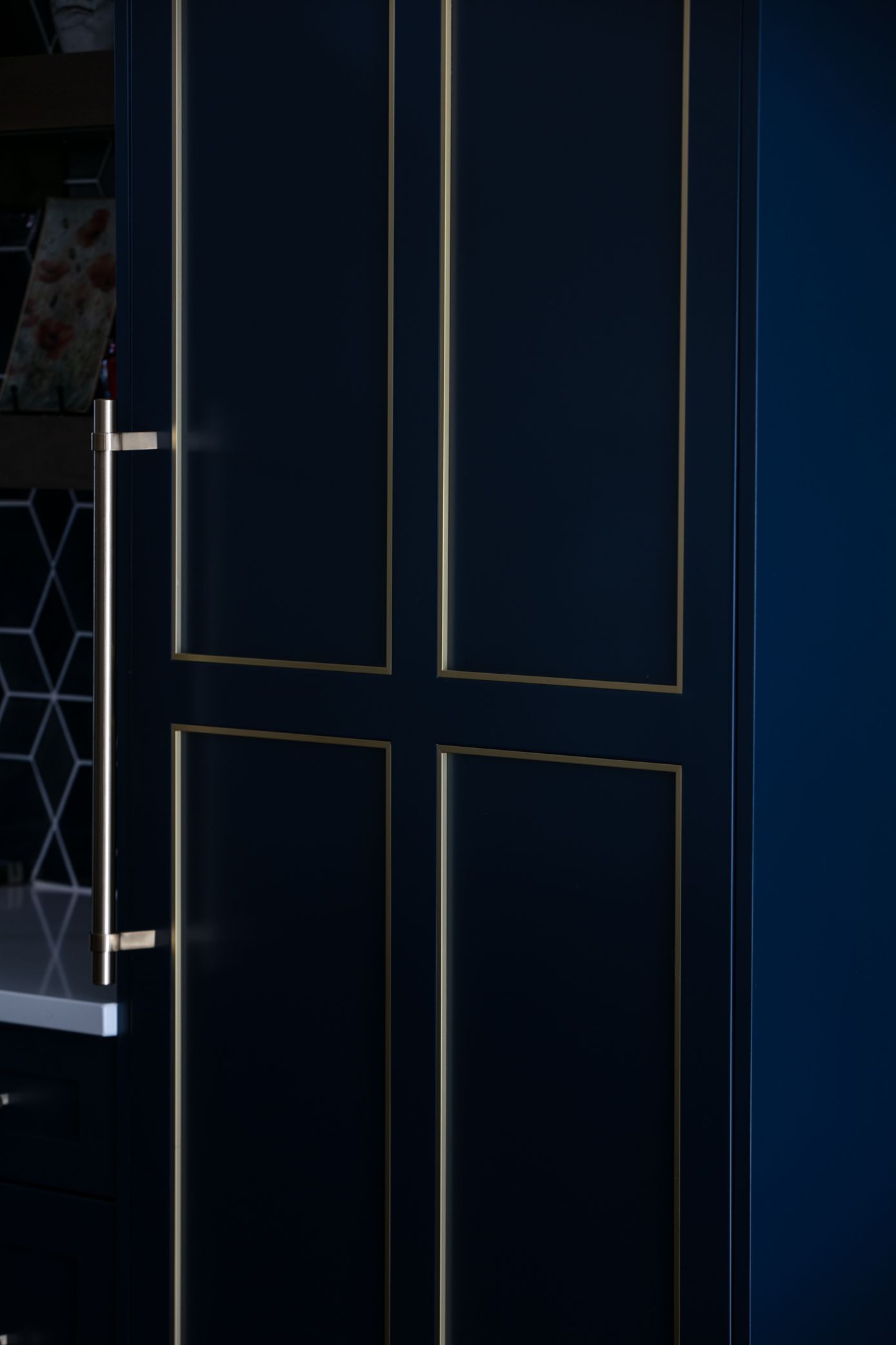 Dark blue cabinet doors with gold trim and a silver handle.
