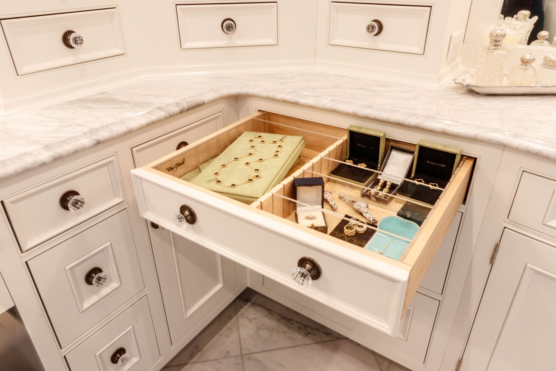 White jewelry drawer, open to reveal rings and necklaces in boxes, and dividers.