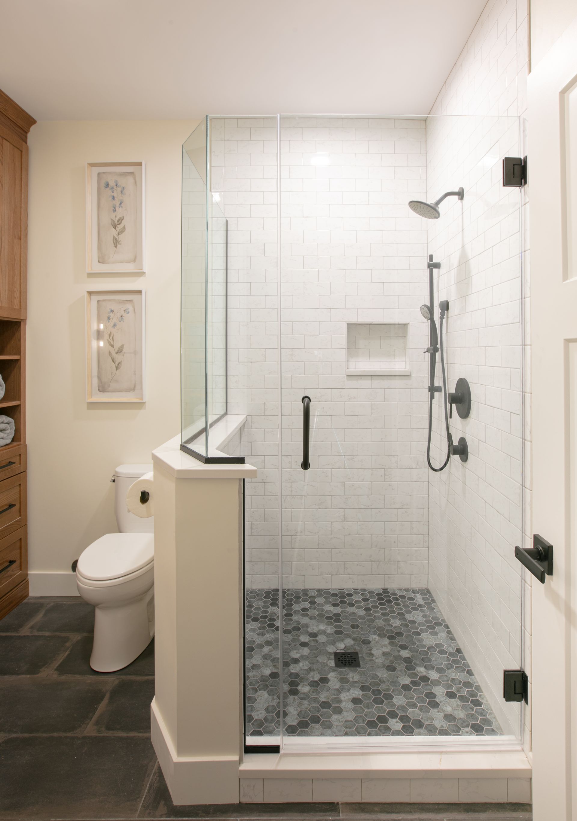 Bathroom with glass shower, white subway tile, and pebble shower floor.