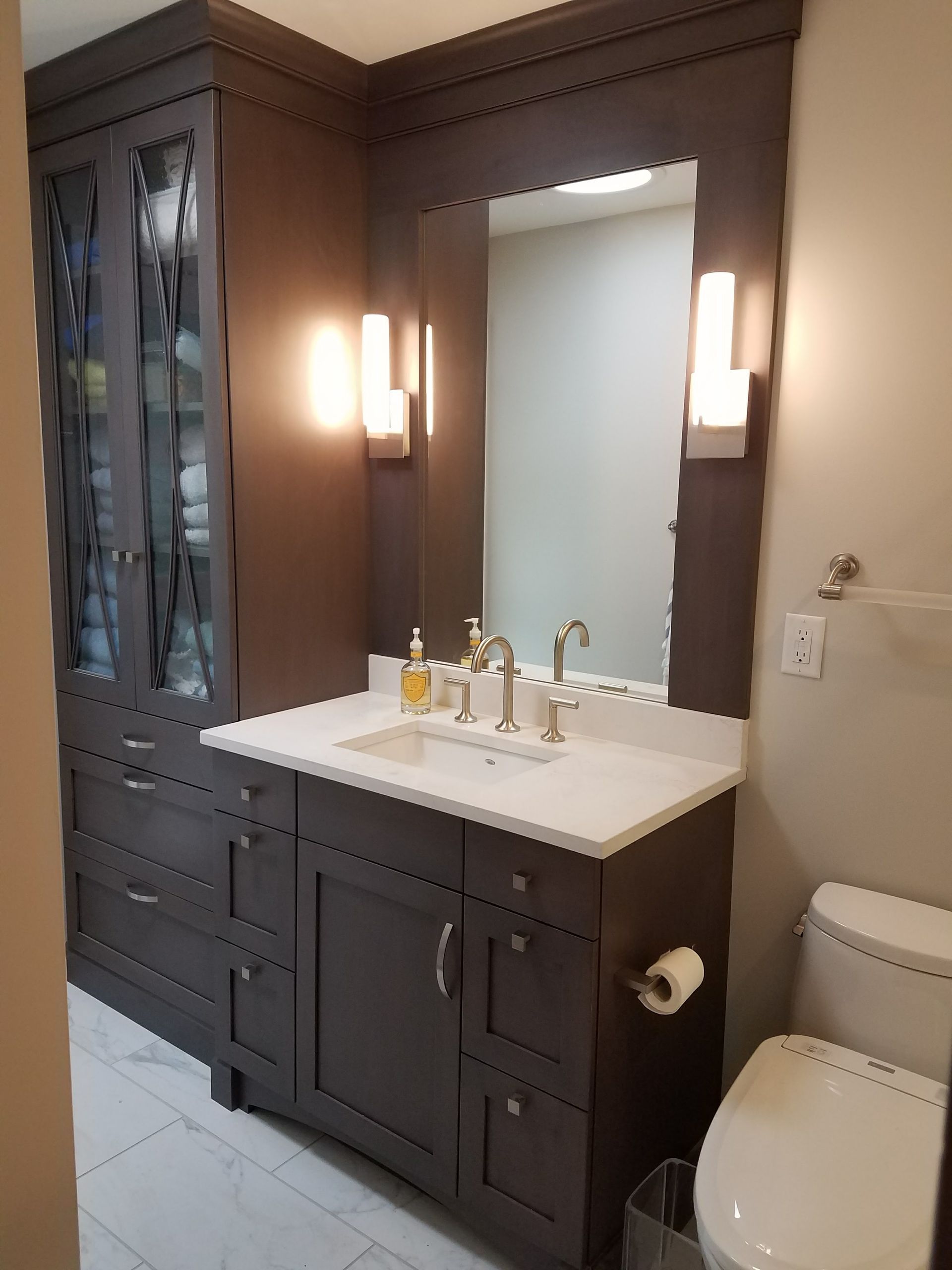 Dark gray bathroom with vanity, storage cabinet, mirror, and toilet.