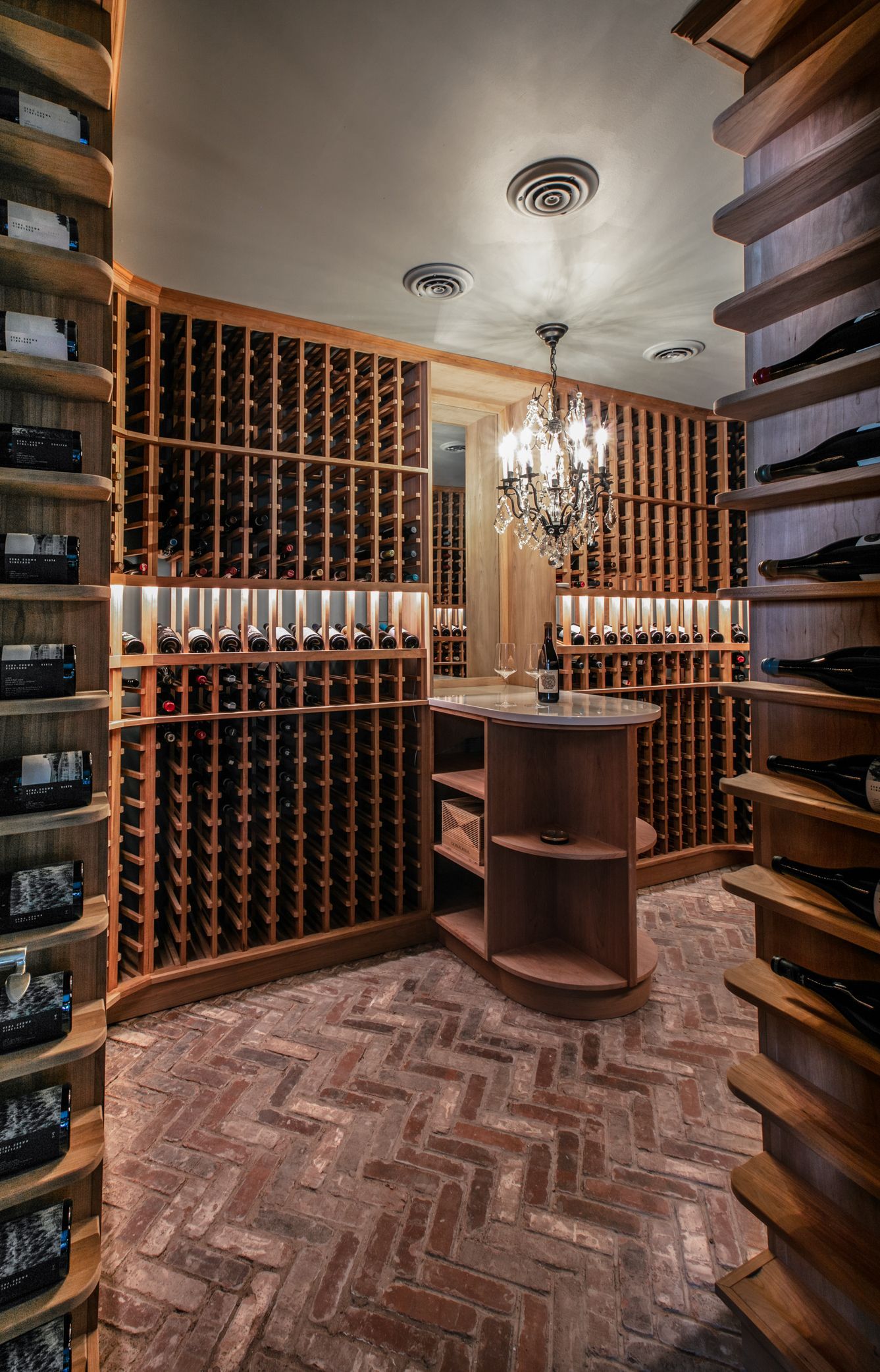Wine cellar with brick floor and wooden shelves filled with wine bottles.