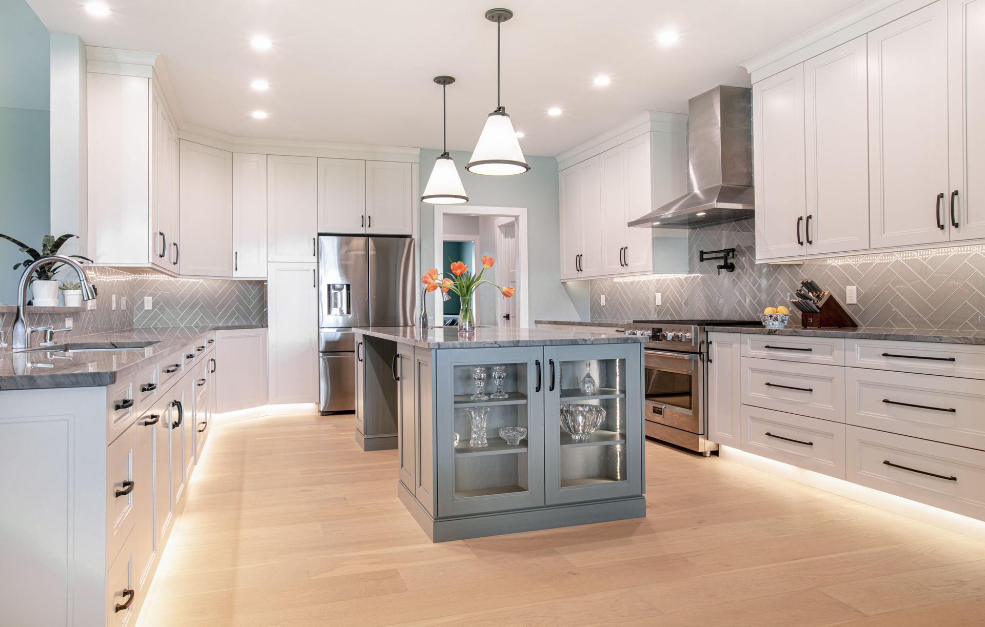 Bright, modern kitchen with white cabinets, stainless steel appliances, and a gray island.