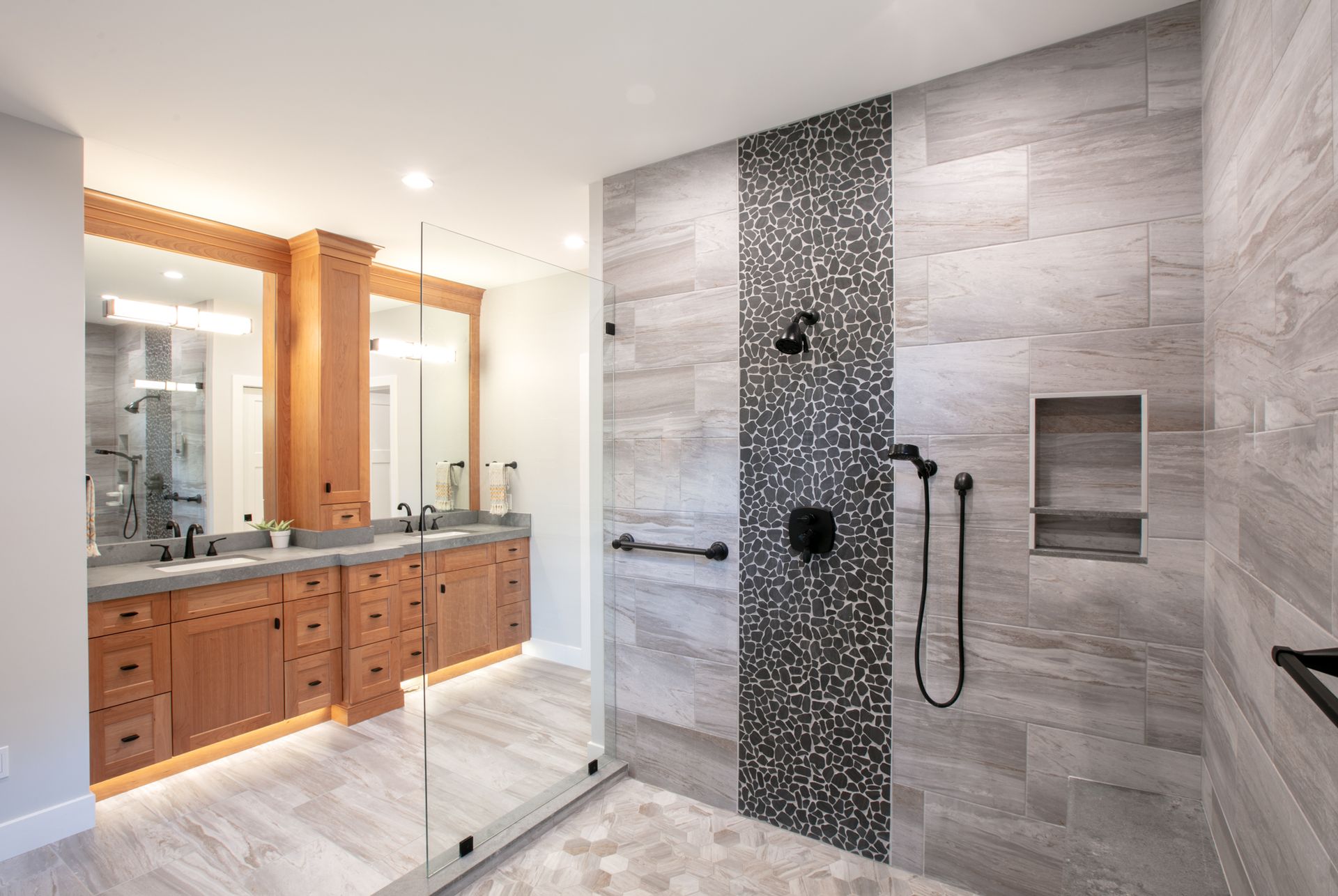Bathroom with double vanity and large walk-in shower; gray and brown tones.