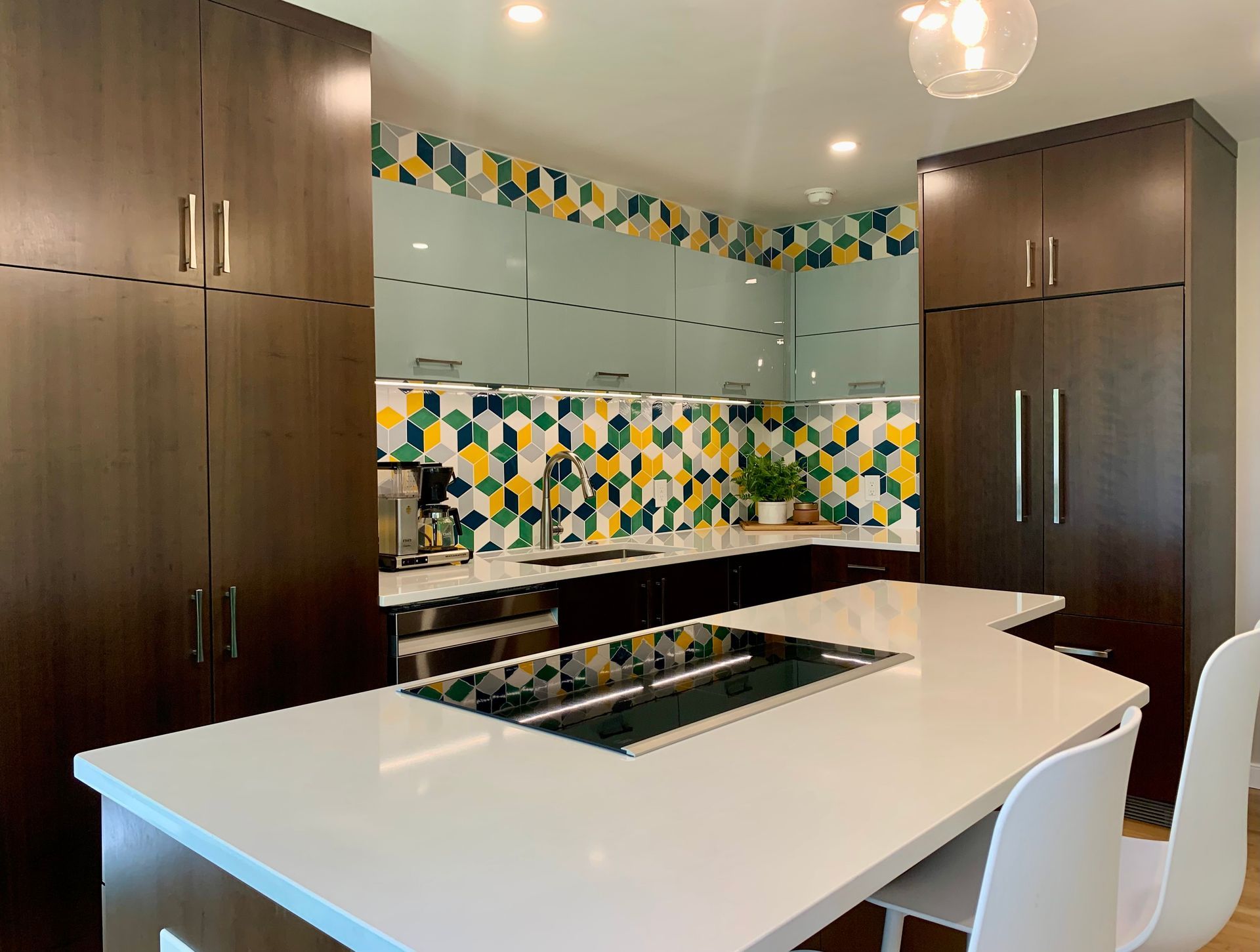 Modern kitchen with dark brown cabinets, white island, and colorful backsplash.