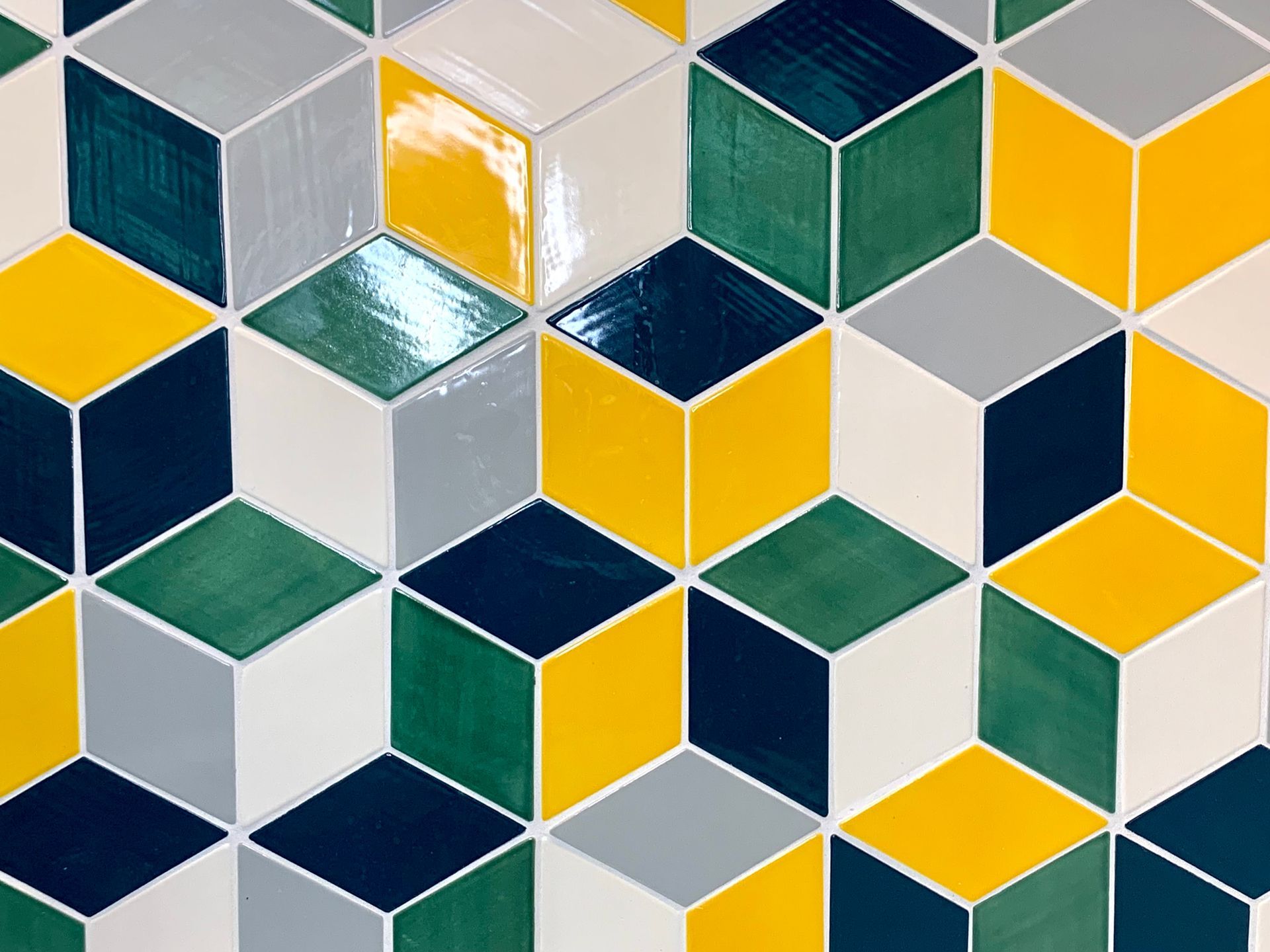 Geometric tile pattern with 3D cubes in yellow, green, gray, white, and navy blue.