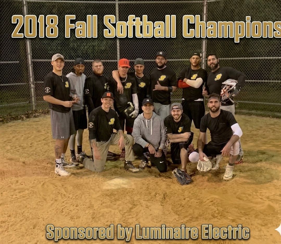 2018 Fall Softball Champions team posing on a field, with sponsor text for Luminaire Electric
