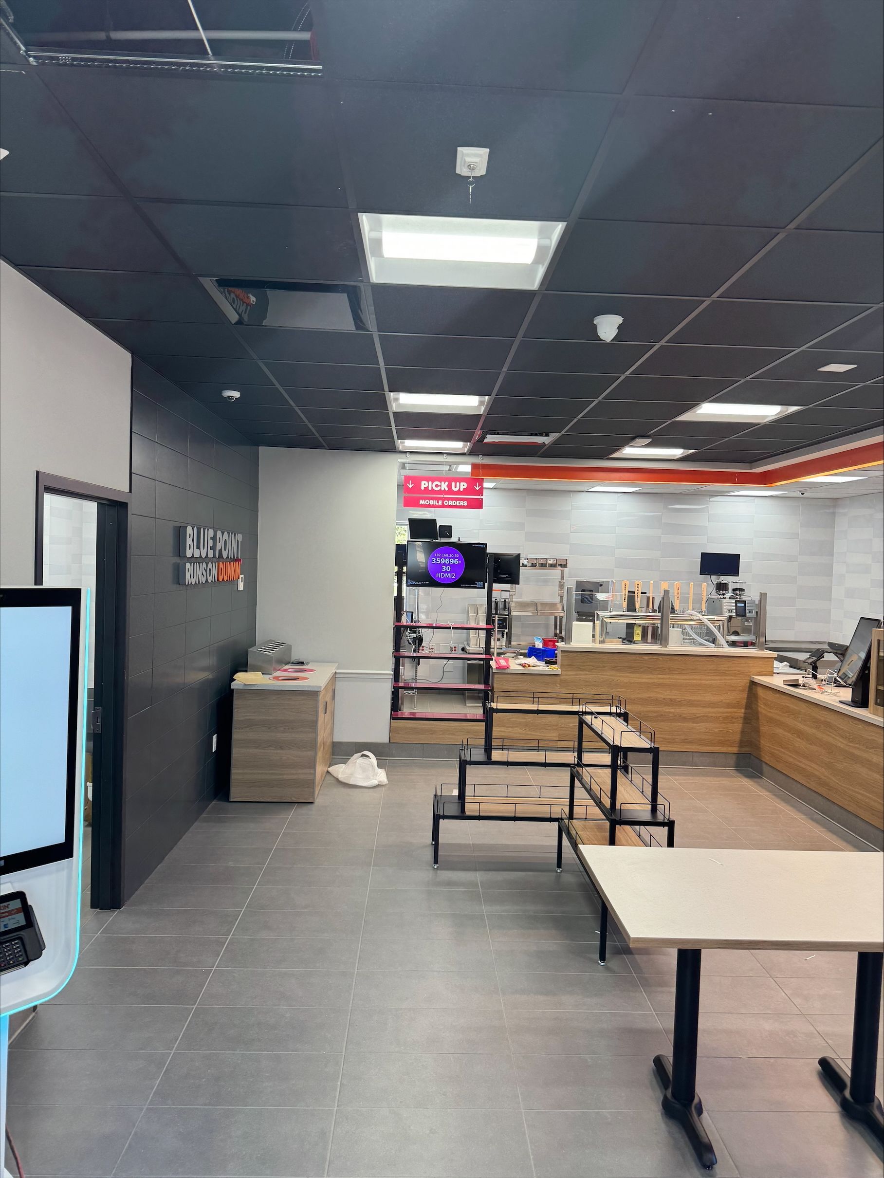 A large room with tables and a TV in it.