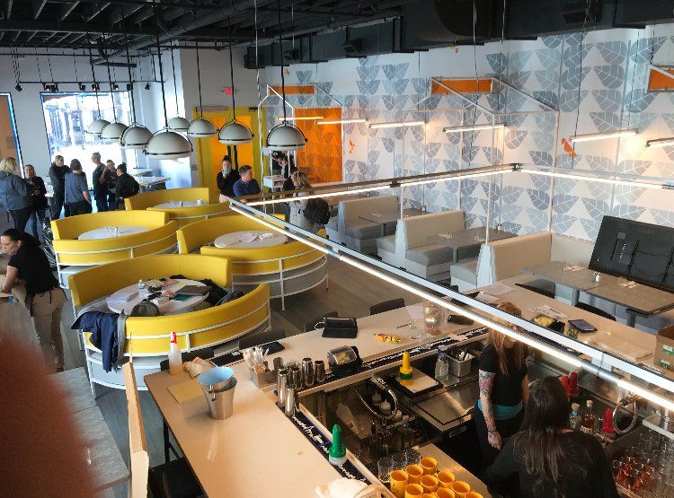 A group of people are sitting at tables in a restaurant.