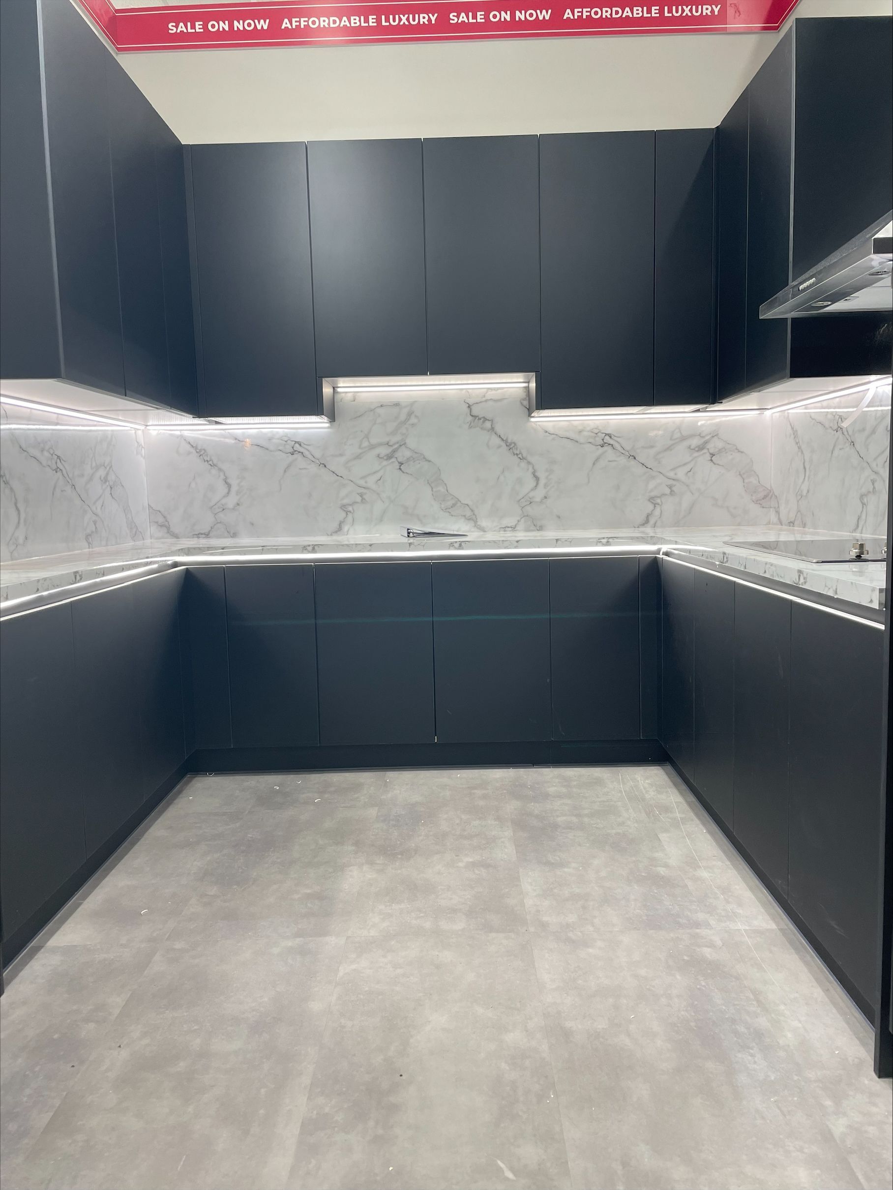 A kitchen with black cabinets and marble counter tops