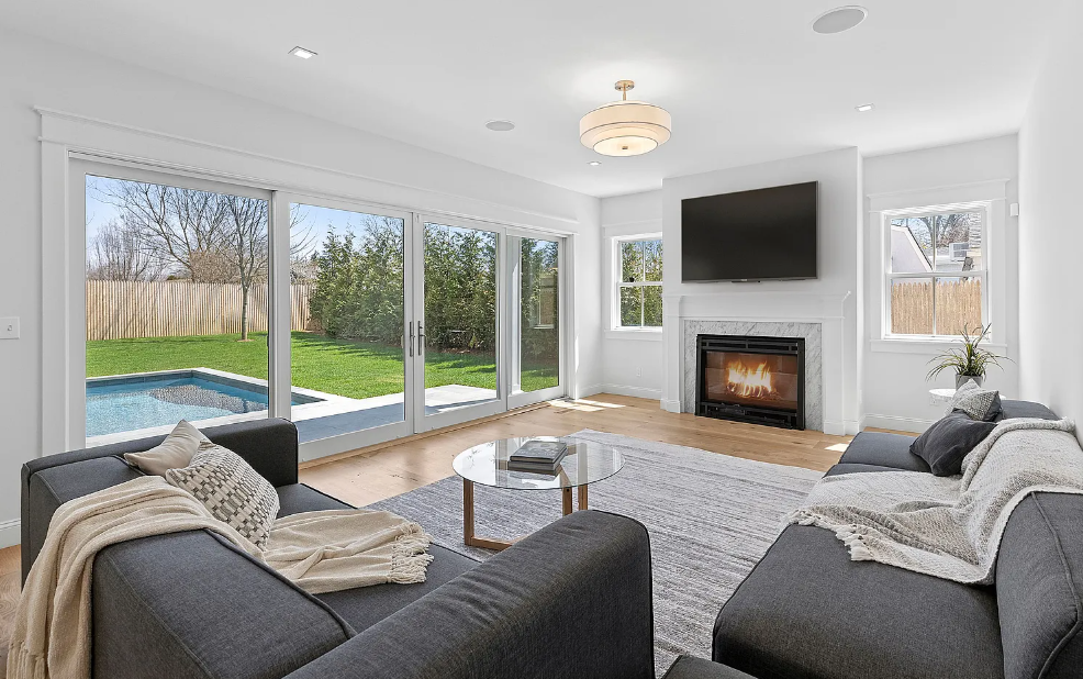 A living room with two couches, a fireplace, and a flat screen TV.