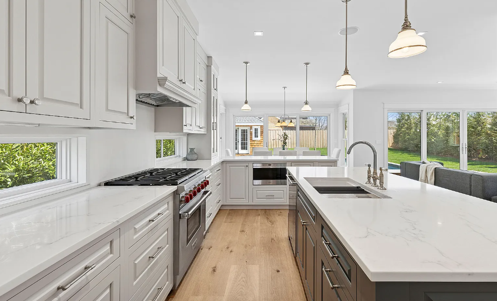 A dining room with a wooden table and white chairs.