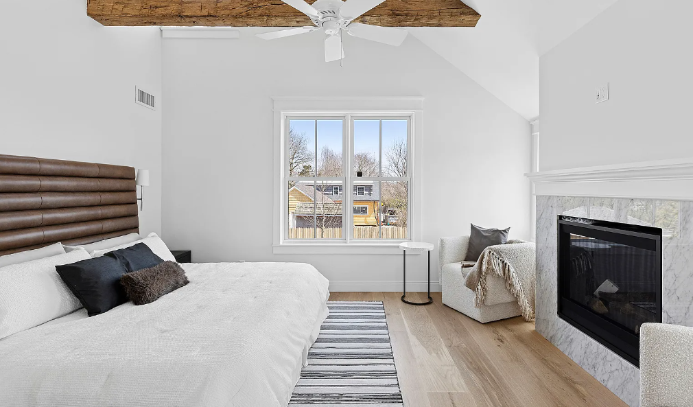 A bedroom with a fireplace and a large bed.