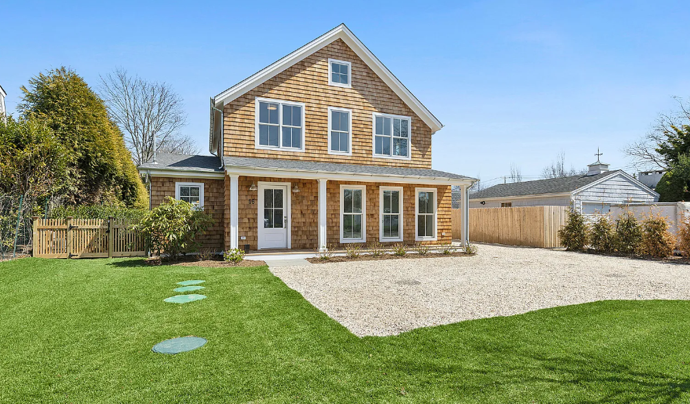 A large house with a gravel driveway in front of it