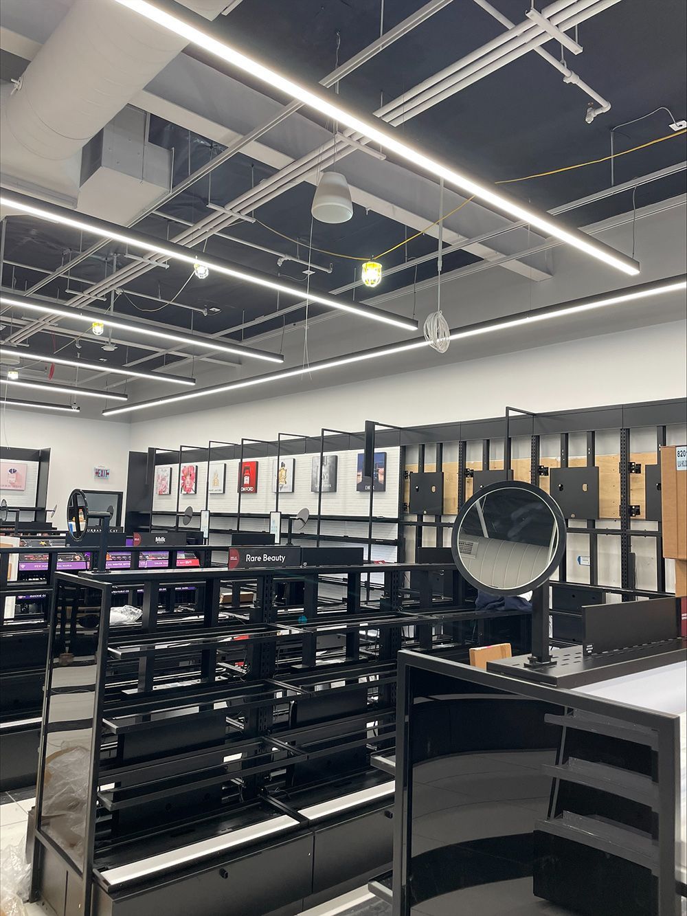 A large room with lots of shelves and a mirror in a store.