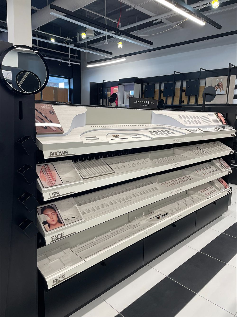A row of empty shelves in a store with a mirror.