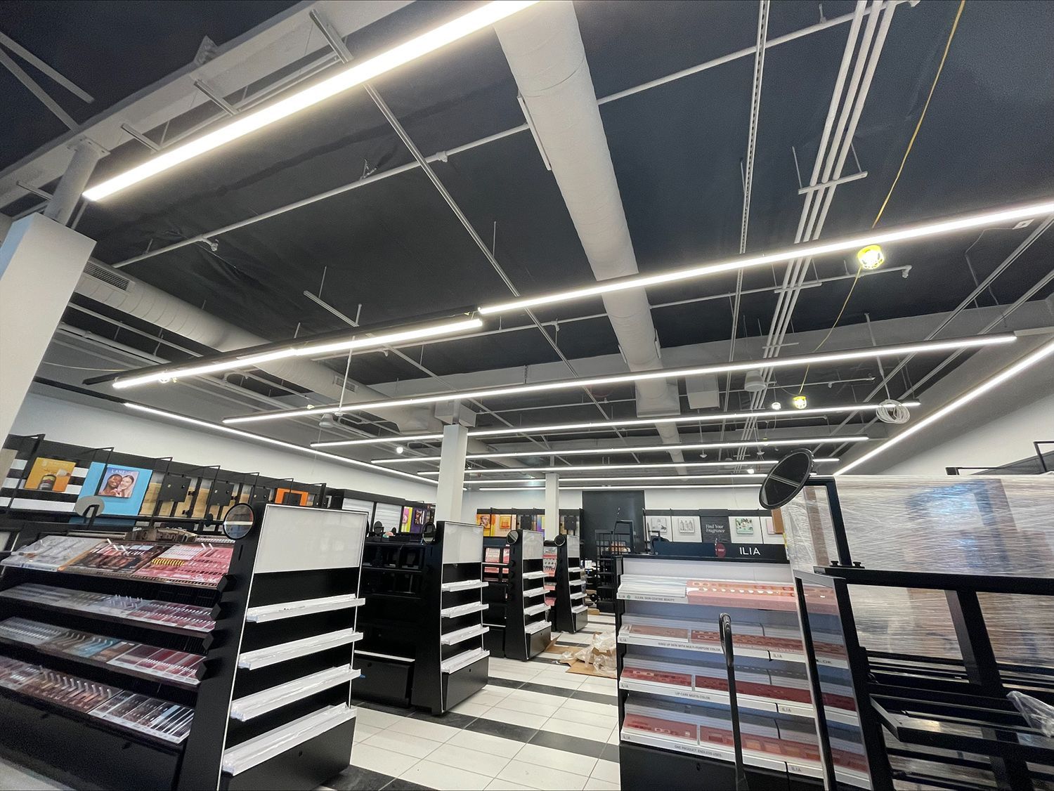A large store with a lot of shelves and lights on the ceiling.
