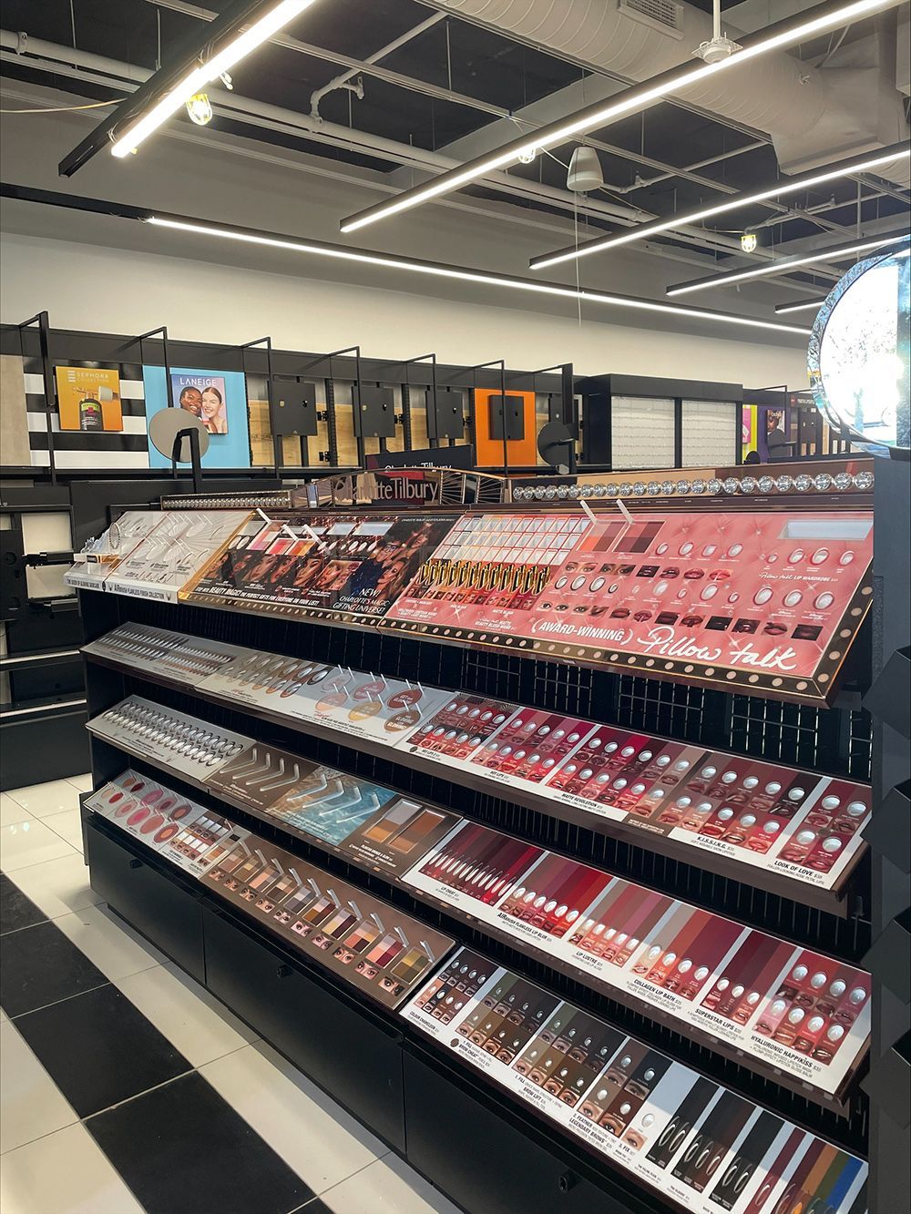 A row of shelves filled with lots of lipsticks in a store.
