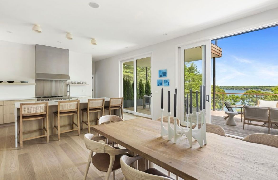 A kitchen and dining room in a house with a large table and chairs