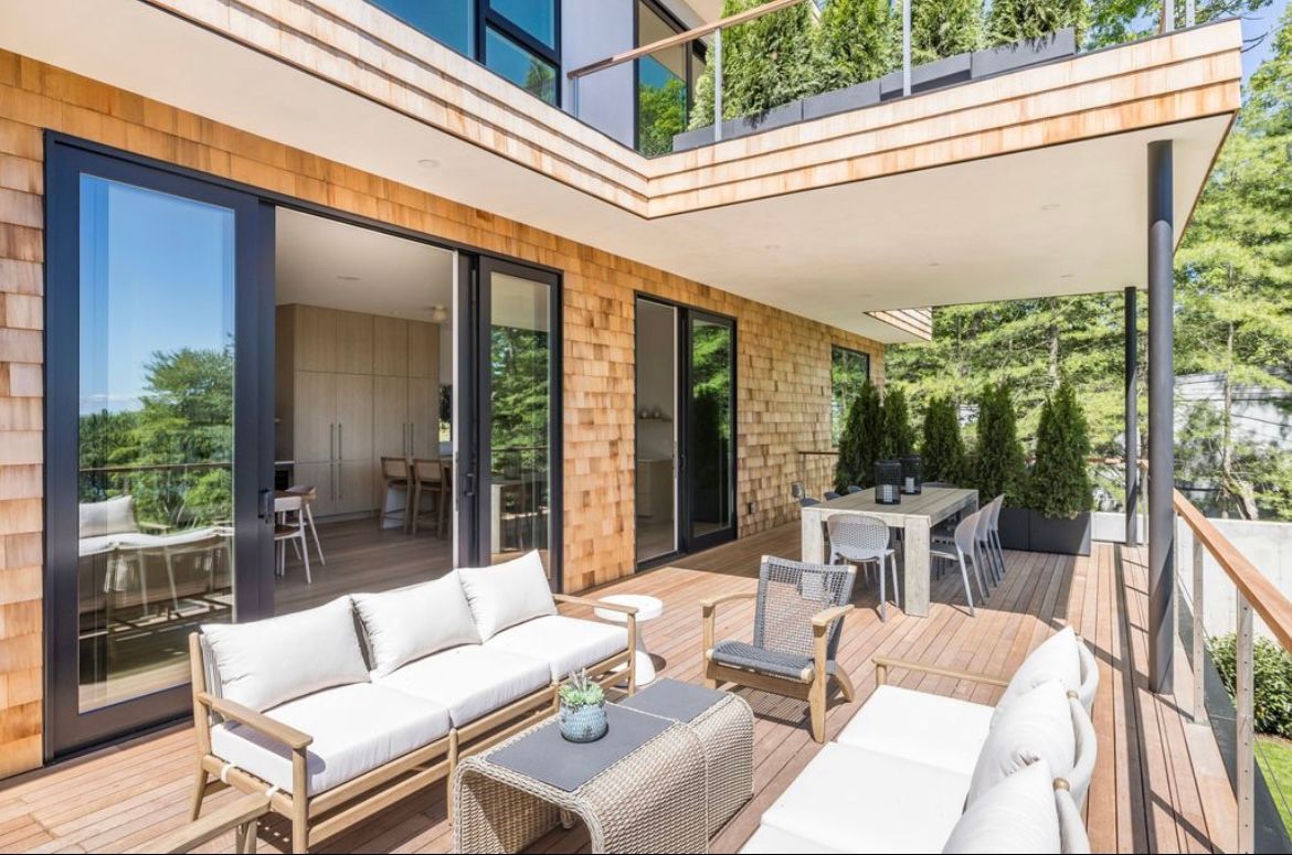 A patio with a couch, table, chairs and sliding glass doors