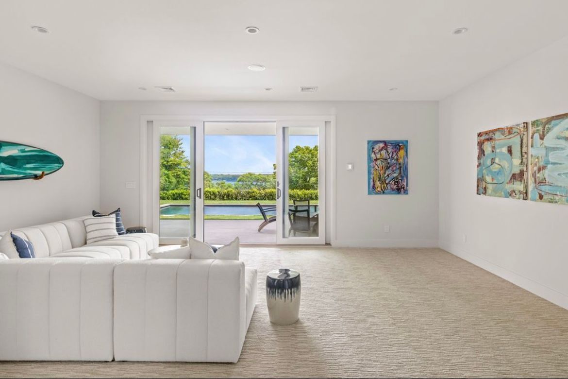 A living room with a white couch and sliding glass doors leading to a patio