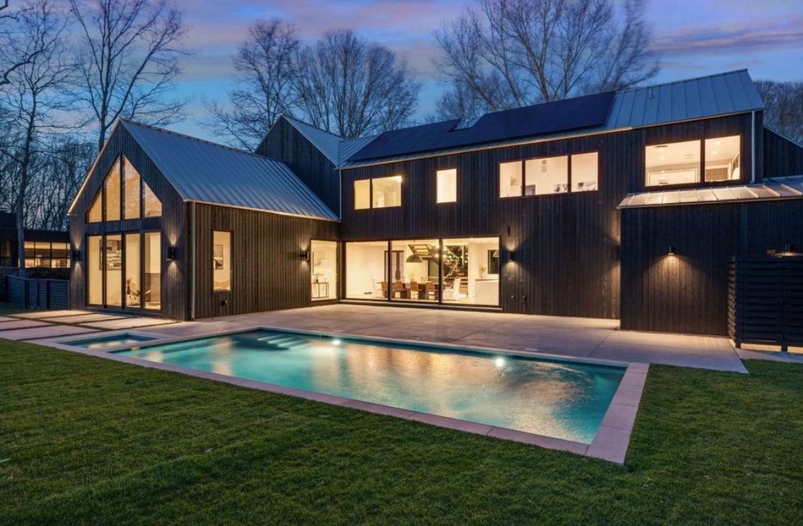 A large house with a swimming pool in front of it