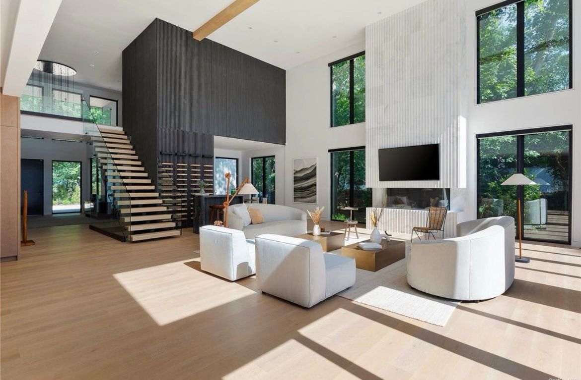 A living room filled with furniture and a staircase in a house